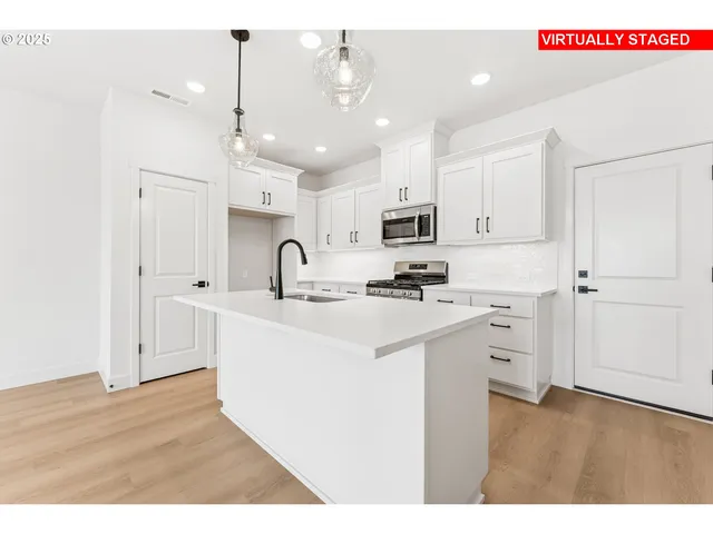 a kitchen with kitchen island a sink stainless steel appliances and cabinets