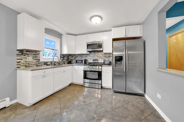 a kitchen with white cabinets and stainless steel appliances