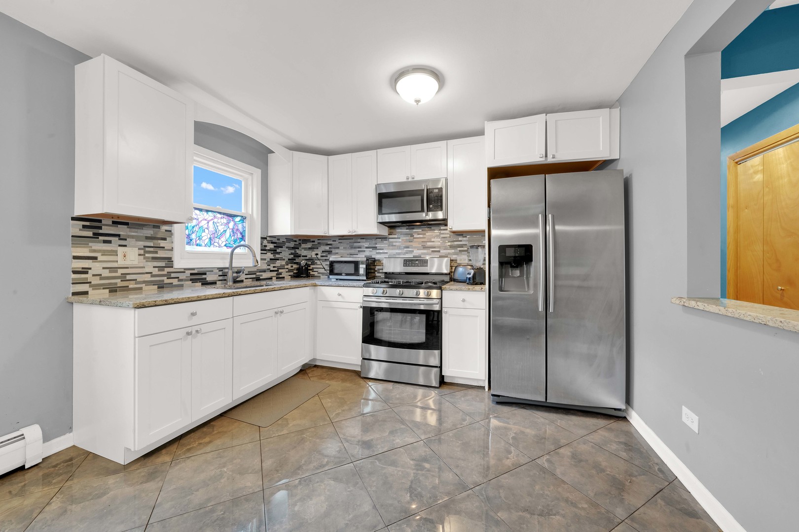 3847 West 47th Street, Unit 1E Chicago, IL 60632 - Photo 6 of 14 a kitchen with white cabinets and stainless steel appliances