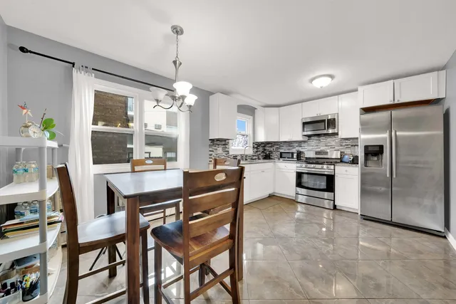 a kitchen with kitchen island white cabinets and refrigerator