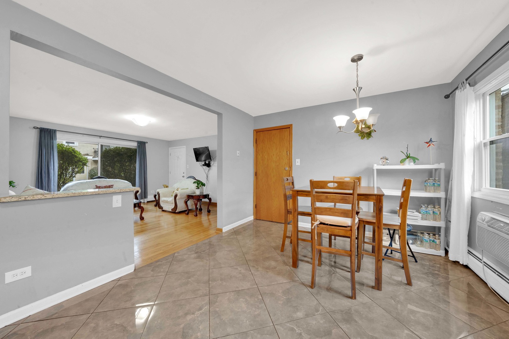 3847 West 47th Street, Unit 1E Chicago, IL 60632 - Photo 9 of 14 a view of a dining room and livingroom with furniture a rug a fireplace and a chandelier