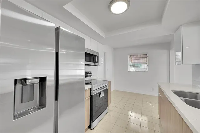 a kitchen with stainless steel appliances granite countertop a refrigerator and a sink