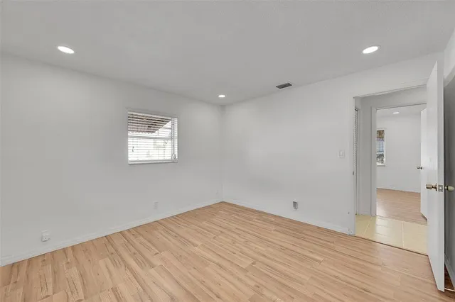 a view of empty room with wooden floor
