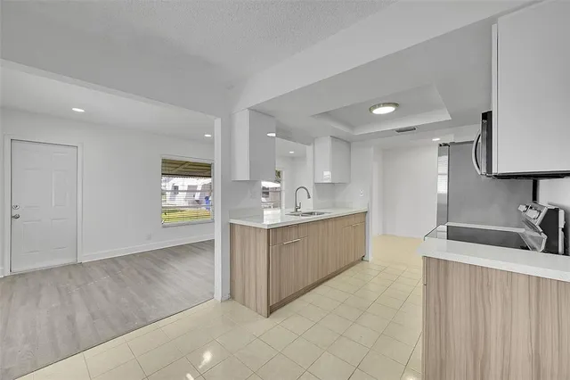 a large kitchen with stainless steel appliances a sink dishwasher stove and cabinets