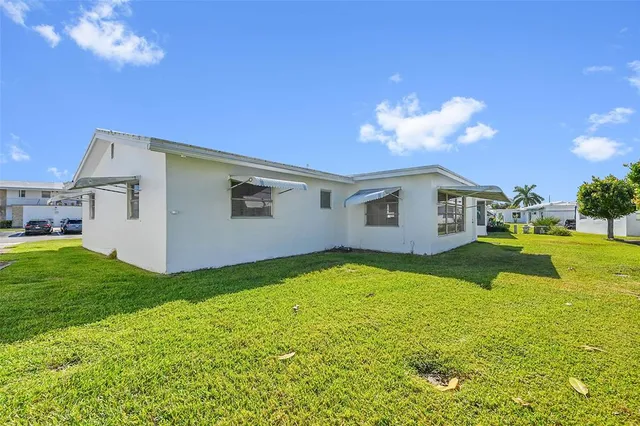 a view of a house with backyard and a patio