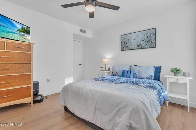 a spacious bedroom with a bed and a cabinets