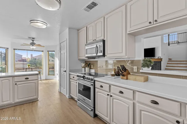 a kitchen with stainless steel appliances granite countertop a stove and white cabinets