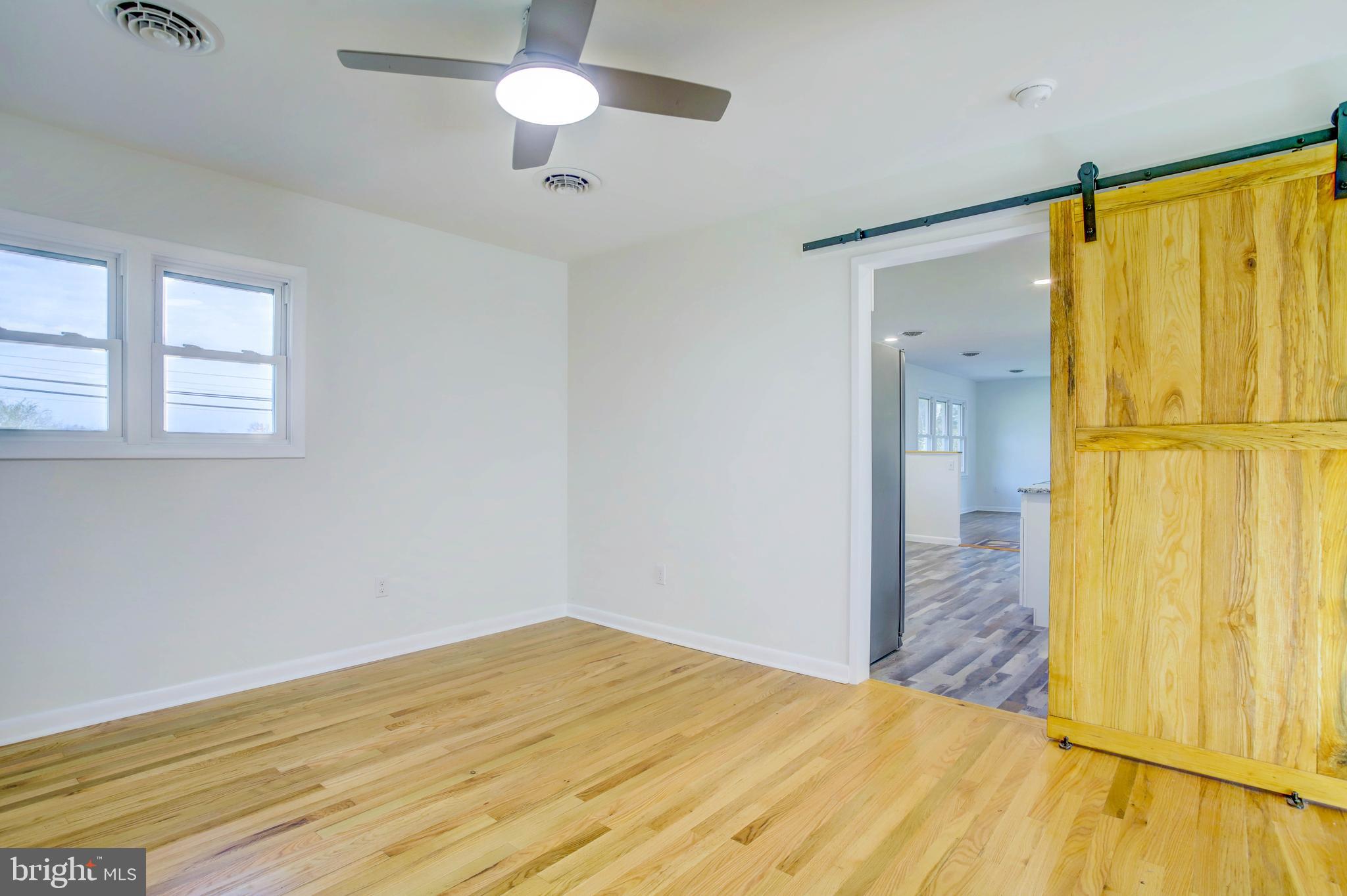 2229 Hudson Road Cambridge, MD 21613 - Photo 32 of 41 a view of a bedroom with wooden floor and a ceiling fan