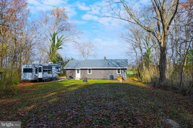 a view of a house with a big yard and large trees