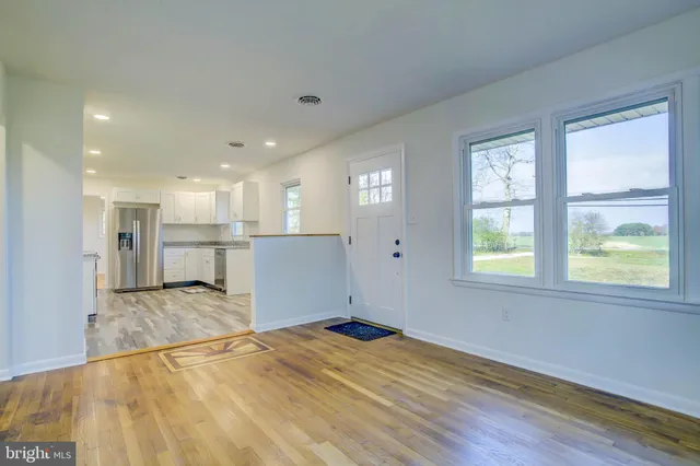 a view of a room with wooden floor and a window