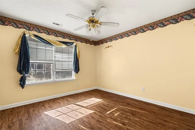 a view of a hallway with a chandelier fan and wooden floor