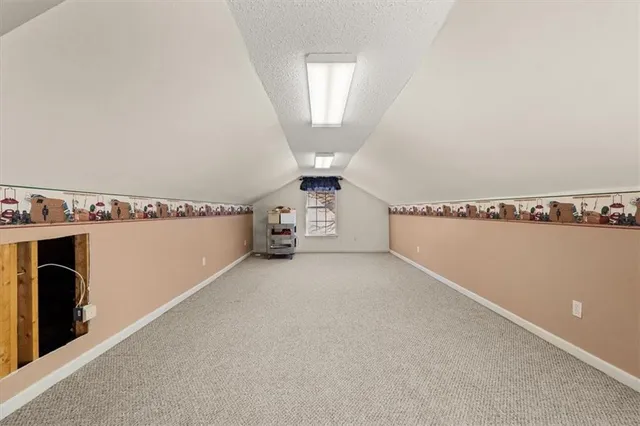 an empty room with chandelier fan and windows