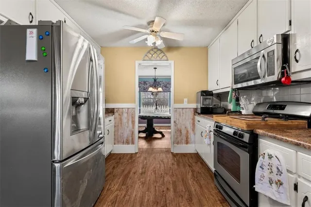 a kitchen with stainless steel appliances granite countertop a stove cabinets and refrigerator