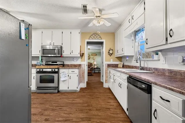 a kitchen with stainless steel appliances granite countertop a refrigerator a stove a sink and a microwave