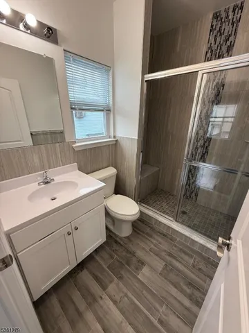 a bathroom with a sink a toilet a mirror and shower