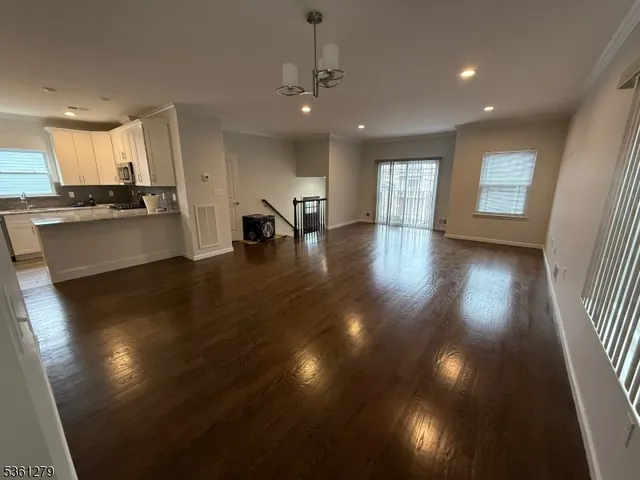 a view of empty room with wooden floor and windows
