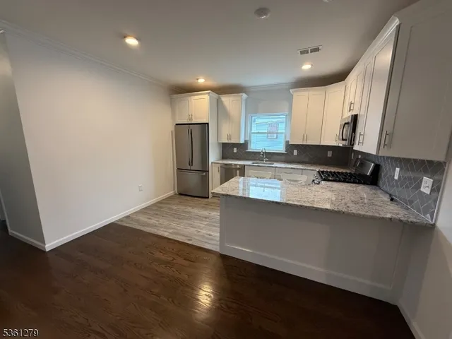 a kitchen with stainless steel appliances granite countertop a refrigerator and a sink