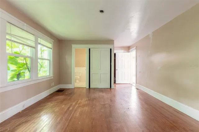 a view of an empty room with window and cabinet