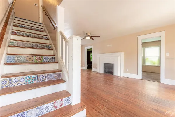 a view of an entryway with wooden floor fireplace and windows