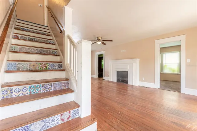 a view of an entryway with wooden floor fireplace and windows