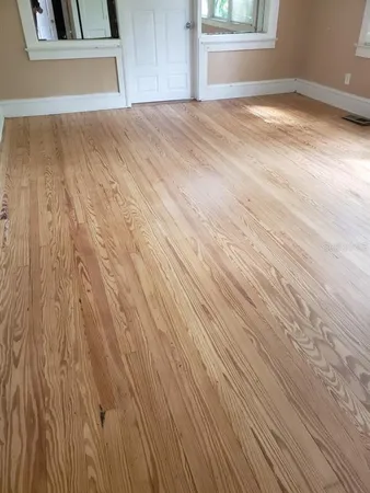a view of empty room with window and wooden floor