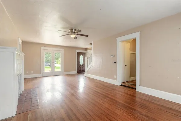 a view of an empty room with window and wooden floor