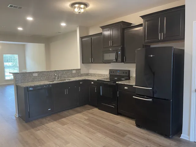 a kitchen with granite countertop a refrigerator and a sink