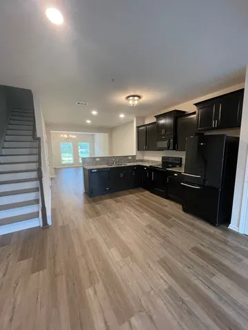 a view of kitchen with refrigerator microwave and cabinets