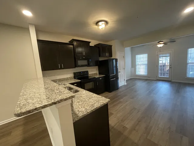 a kitchen with stainless steel appliances granite countertop a sink and a stove top oven