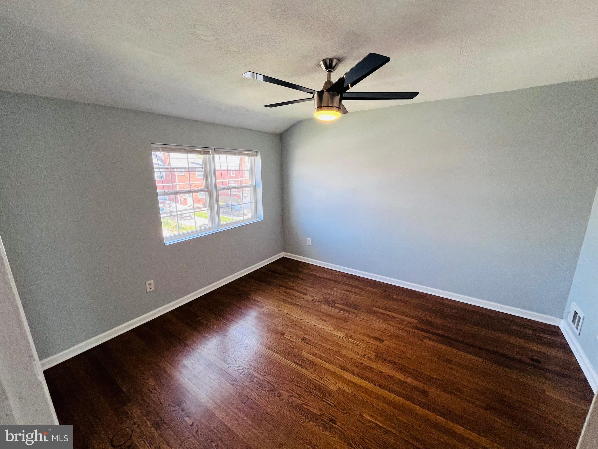 830 Arncliffe Road Baltimore, MD 21221 - Photo 7 of 12 a view of empty room with wooden floor and fan