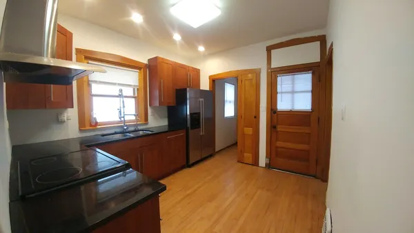 a kitchen with stainless steel appliances granite countertop a refrigerator and a stove