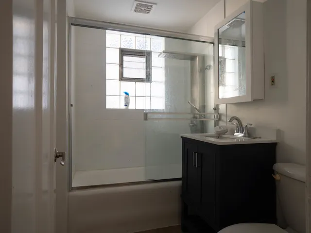 a bathroom with a sink toilet a mirror and window