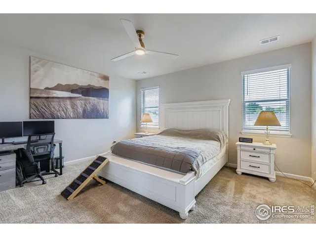 a bedroom with a bed a table and painting on the wall