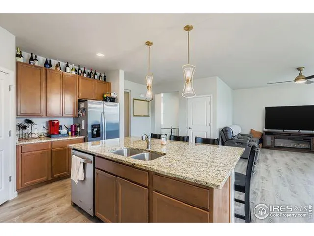 a kitchen with kitchen island granite countertop a sink cabinets and stainless steel appliances