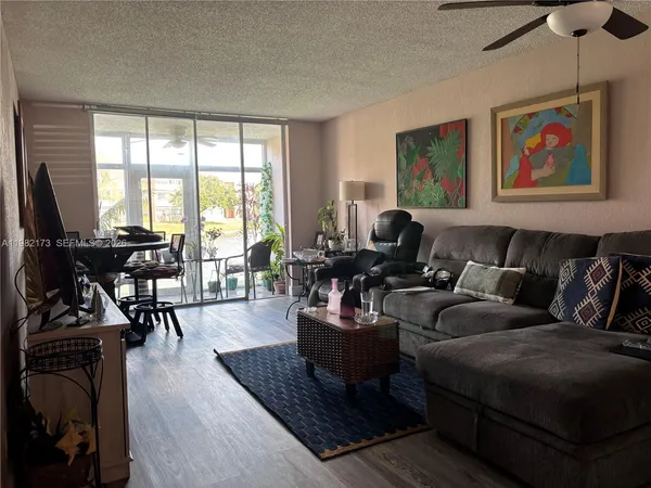 a living room with furniture a flat screen tv and a large window