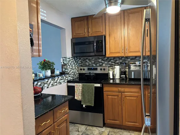 a kitchen with granite countertop a sink and cabinets