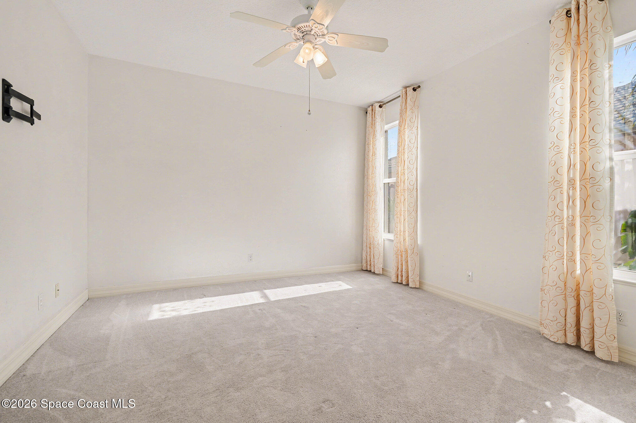4325 Collingtree Drive Rockledge, FL 32955 - Photo 20 of 35 an empty room with a chandelier fan and windows