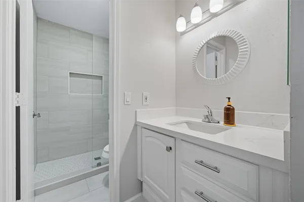 a bathroom with a sink a toilet and a mirror