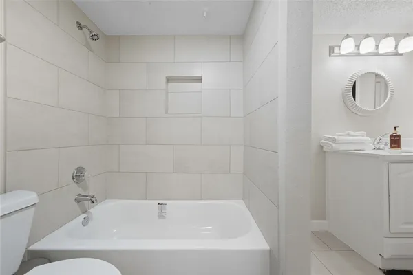 a bathroom with a tub sink and a mirror