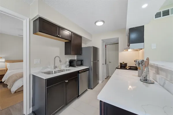 a kitchen with a sink dishwasher a stove and a refrigerator with wooden floor