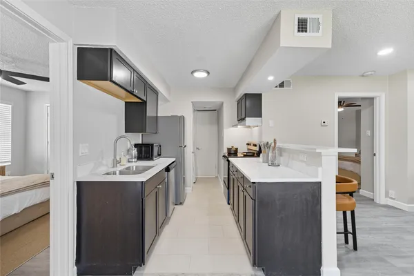a kitchen with stainless steel appliances granite countertop a sink a stove and a refrigerator
