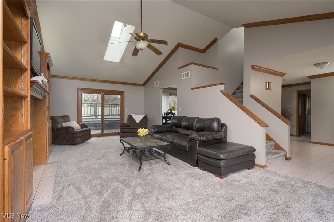 819 Bridge Road Akron, OH 44312 - Photo 14 of 33 Living area with stairway, ceiling fan, crown molding, skylight, and light colored carpet