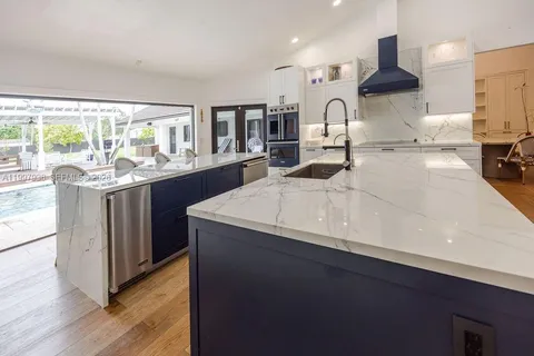 a kitchen with stainless steel appliances granite countertop a sink a stove and a refrigerator