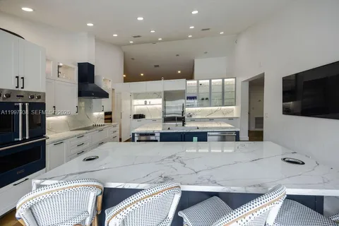 a open kitchen with stainless steel appliances granite countertop a sink and a refrigerator