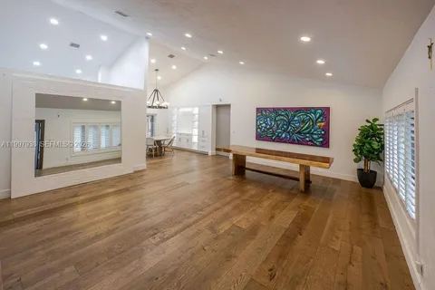 an empty room with wooden floor and a rug