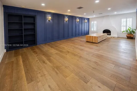 a view of an empty room with a cabinet and a window