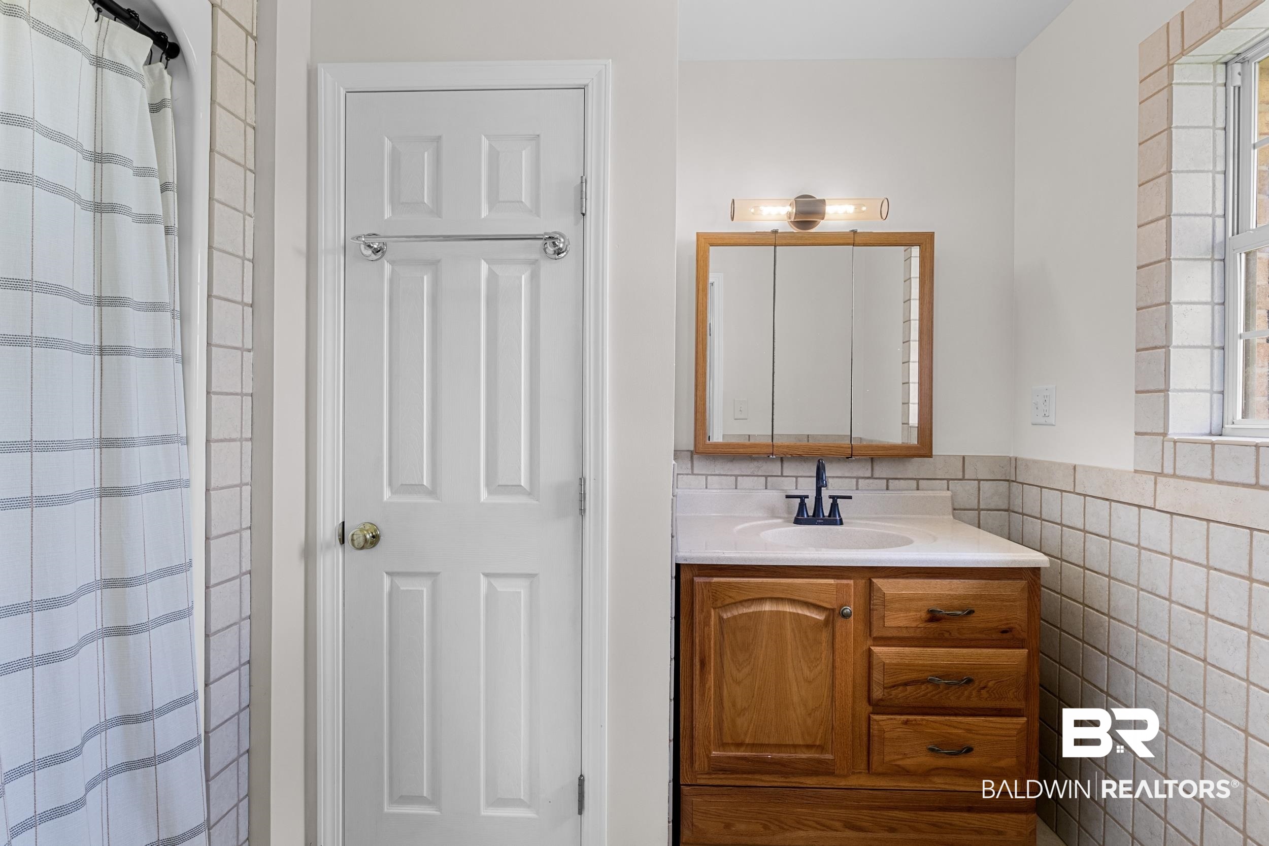 17689 Brewer Road Foley, AL 36535 - Photo 39 of 54 Bathroom with tile walls, vanity, and curtained shower