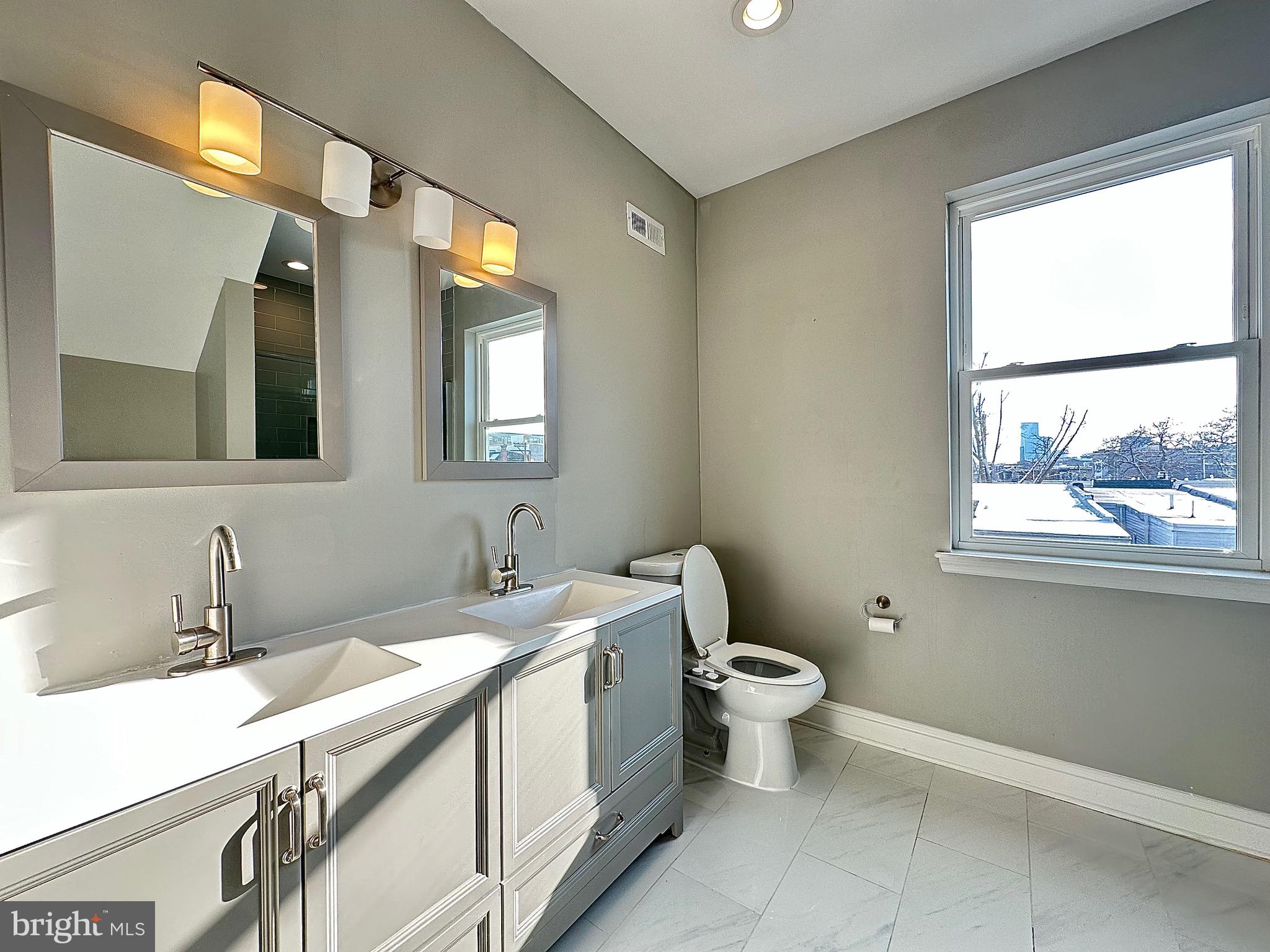 2514 West Seybert Street Philadelphia, PA 19121 - Photo 29 of 38 a bathroom with a double vanity sink toilet and a window