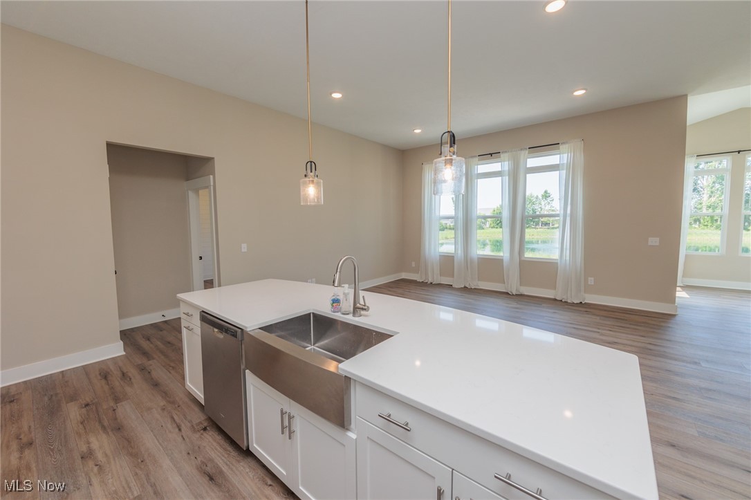 36458 Appian Way North Ridgeville, OH 44039 - Photo 11 of 37 Kitchen featuring pendant lighting, hardwood / wood-style floors, dishwasher, sink, and a center island with sink