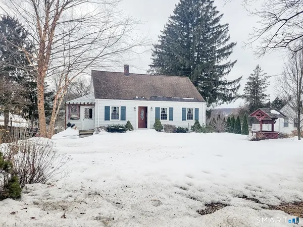 a front view of a house with a yard covered in snow